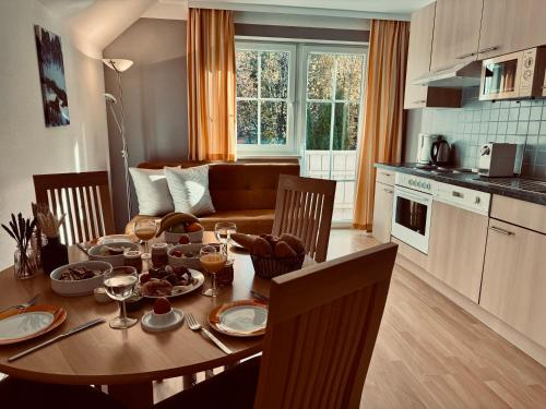 a kitchen and dining room with a wooden table with wine glasses at Dependance I in Schladming