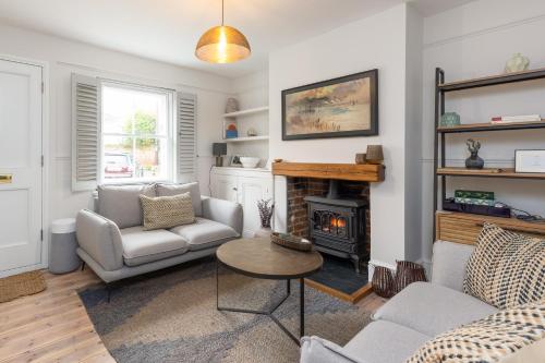 a living room with a couch and a fireplace at Charming 2 Bed Cottage - within city walls - free parking- garden in Canterbury