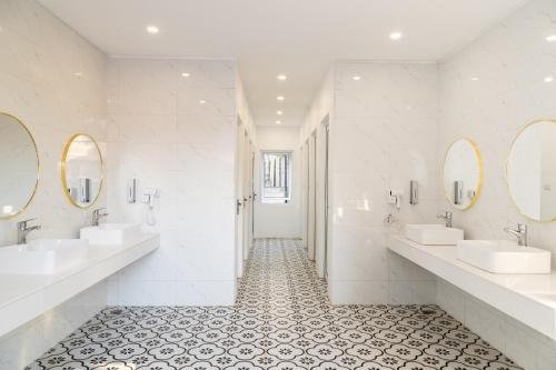 un baño con dos lavabos y dos espejos en White Elephant Hostel, en Luang Prabang