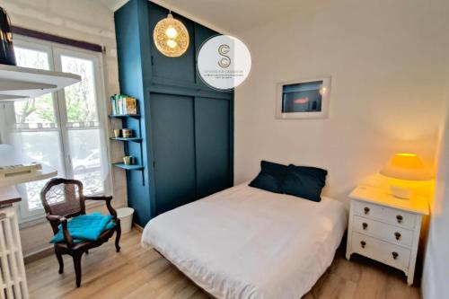 a small bedroom with a bed and a chair at Les Alys Arles Centre in Arles