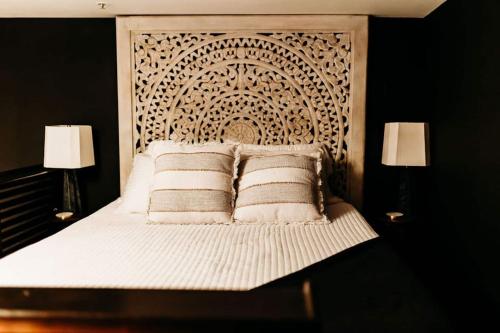 a bedroom with a white bed with two lamps at Sol Sage Studio Downtown in Wilmington