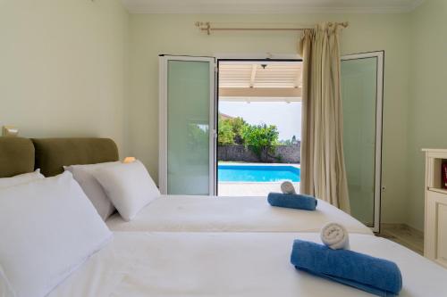 a bedroom with two beds and a view of a pool at Villa Nefeli Breeze in Dassia