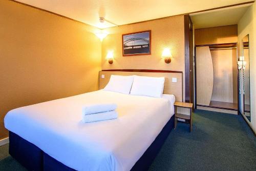 a hotel room with a large bed with two towels on it at The Raceby Hotel, Doncaster South Yorkshire, Part of the AG Collection in Doncaster