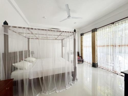 a bedroom with a bed with a mosquito net at Villa Olga in Unawatuna