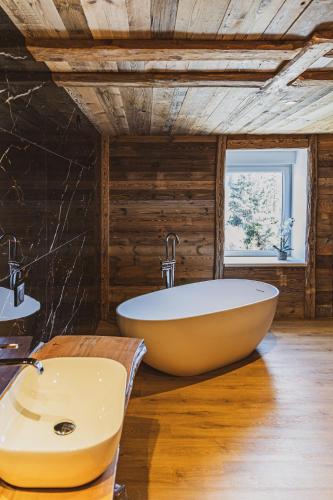 a bathroom with a tub and a sink at La Charbonnière, grand gîte haut-de-gamme avec jacuzzi et sauna in Gérardmer