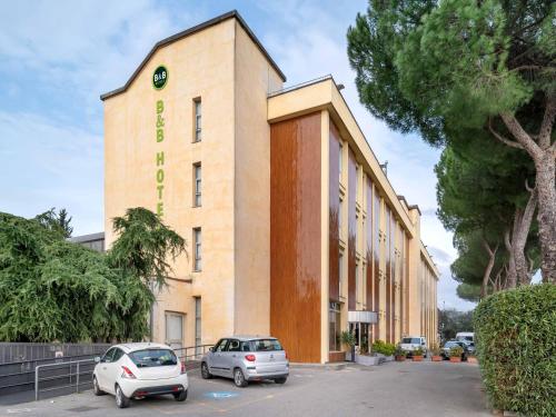 a building with cars parked in front of it at B&B HOTEL Calenzano First in Calenzano