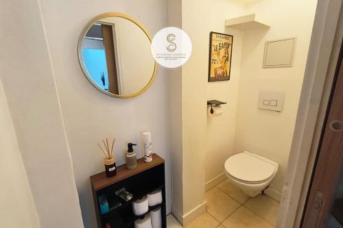 a bathroom with a toilet and a mirror at La Pitchoune Arles Centre in Arles