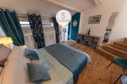 a bedroom with a large bed with blue walls at La Pitchoune Arles Centre in Arles