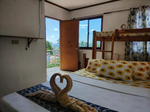 a room with a bed with a swan on it at Brenmariel Tourist Inn in El Nido