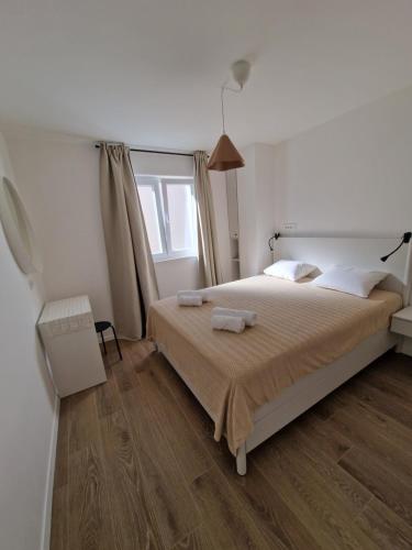 a bedroom with a bed with two towels on it at Apartmani Tribunj Cvitan in Tribunj