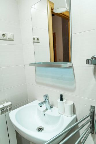 a white bathroom with a sink and a mirror at Piso en Antigua Casa de Correos in Molina de Aragón