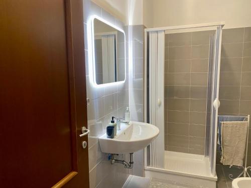 ein Badezimmer mit Waschbecken und Dusche mit Spiegel in der Unterkunft Paper House in Rom
