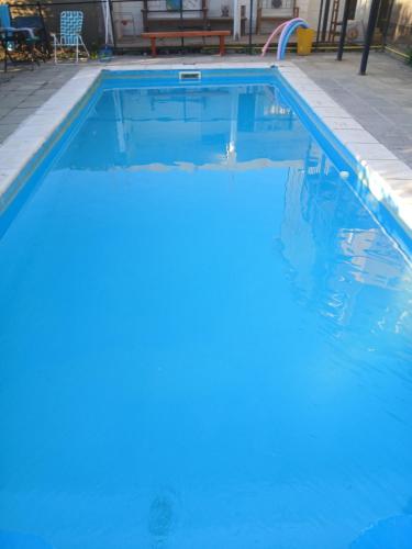 a swimming pool with blue water in at Depto Castillo in El Bolsón