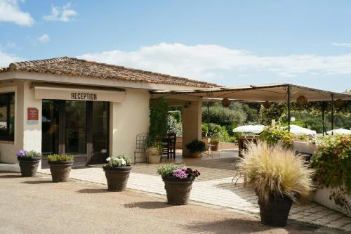 a patio with potted plants in front of a building at Les Hauts de Santa Giulia in Porto-Vecchio