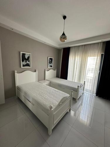 a bedroom with two beds and a window at Serenity Residence duplex in Alanya