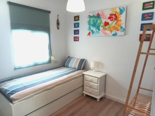 a small bedroom with a bed and a window at Villasultana 1 in Chipiona