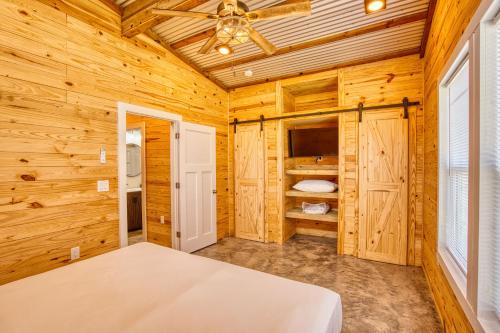 a log cabin bedroom with a bed and a ceiling fan at Lagoon Ranch RV Resort in Onalaska