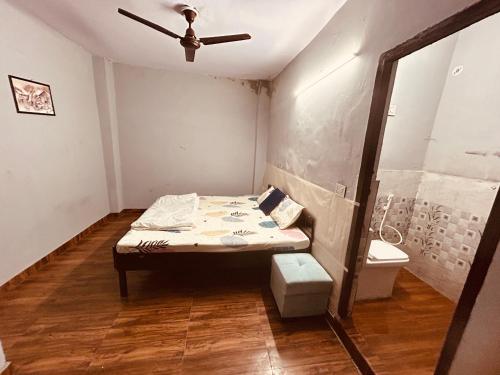 a small room with a bed and a ceiling fan at BTS STAY- Singh Niwas in Ghaziabad