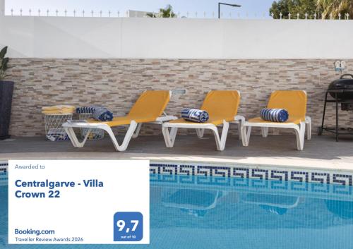 four lounge chairs next to a swimming pool at Centralgarve - Villa Crown 22 in Quarteira