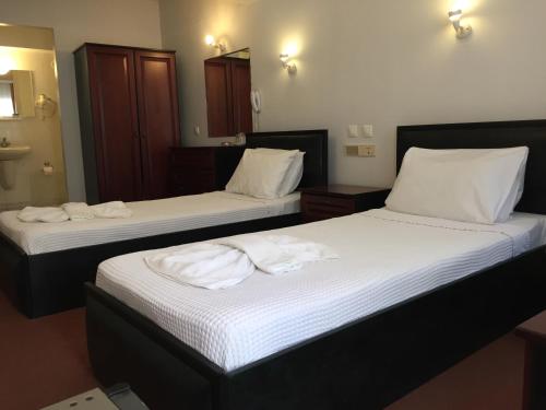 two beds in a hotel room with towels on them at Hotel Balca in Izmir