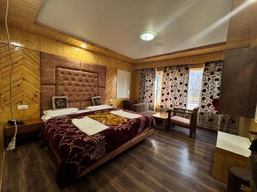 a large bedroom with a large bed and a desk at The River Edge in Pahalgām