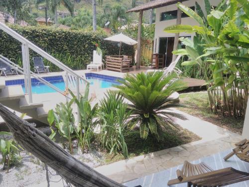 a resort with a hammock and a swimming pool at Mares de Camburizinho in Camburi