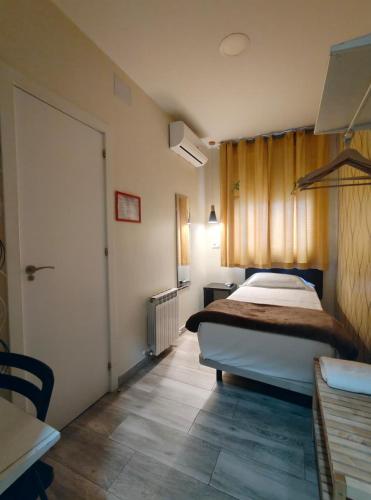 a hotel room with a bed and a door at JQC Rooms in Madrid