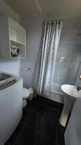 a bathroom with a sink and a toilet and a shower at Cabaña con tinaja Aucaco in Ancud