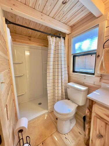 a small bathroom with a toilet and a shower at Cozy Coastal Cabin 1 in Steuben
