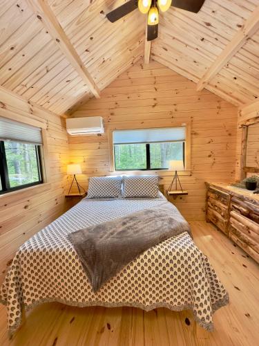 a bedroom with a bed in a wooden cabin at Cozy Coastal Cabin 1 in Steuben