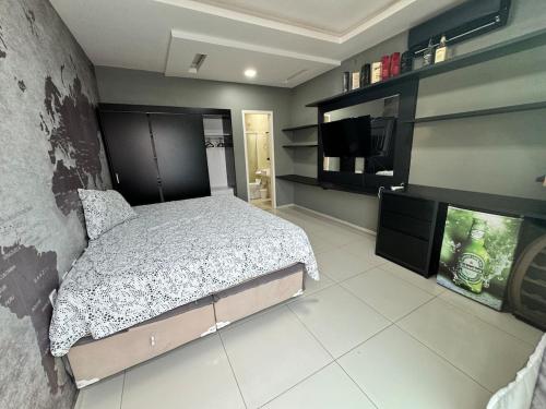 a bedroom with a bed and a flat screen tv at Casa completa com 3 quartos,ar e garagem in Sobral