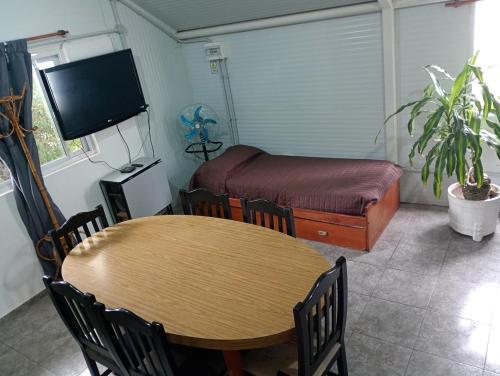 a room with a table and a bed and a desk at Refugio Amaicha in Embalse
