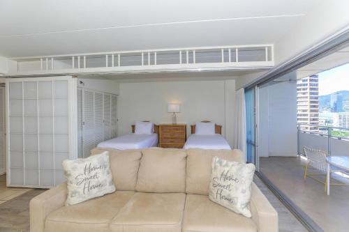 a living room with a couch and a bedroom at Ilikai Tower 1403 in Honolulu