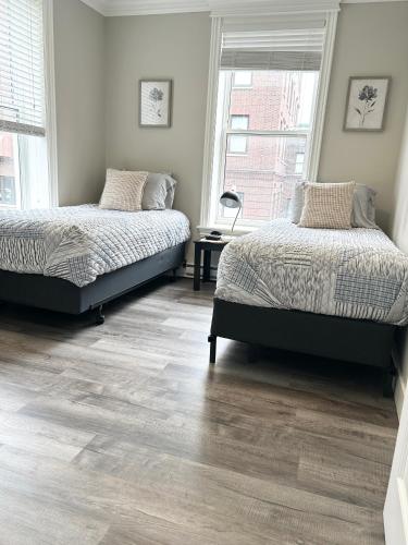two beds in a room with wooden floors at 92179 Newfoundland & Labrador Limited in St. John's