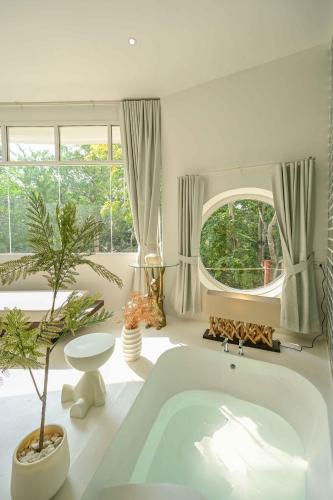 a large white bathroom with a tub and a window at Mooncake house khaoyai in Ban Bung Toei