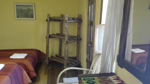 a room with two beds and a ladder in it at Posada Junco y Capuli in Huancayo
