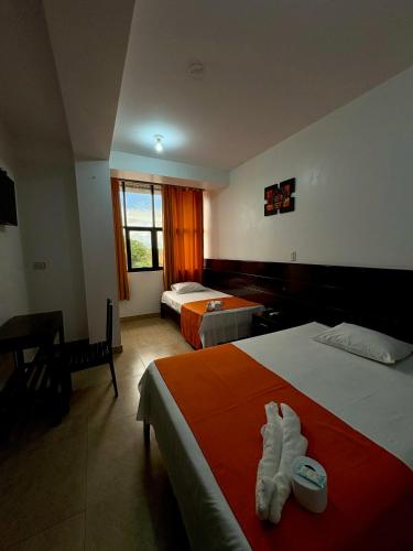 a hotel room with two beds and a window at Hotel Luxor Pucallpa in Pucallpa