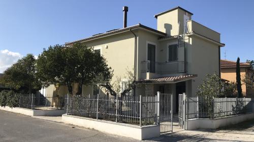 a white house with a fence in front of it at Colombella Apartment Agriturismo Collerisana in Spoleto