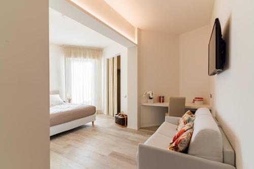 a living room with a couch and a bed at Riviera Hotel in Senigallia