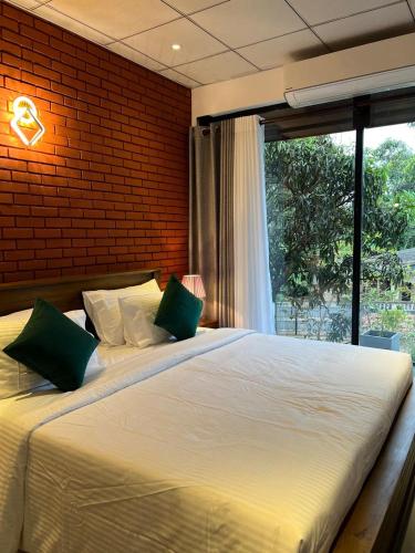 a bedroom with a large bed with a large window at Sol & Luna in Katunayaka
