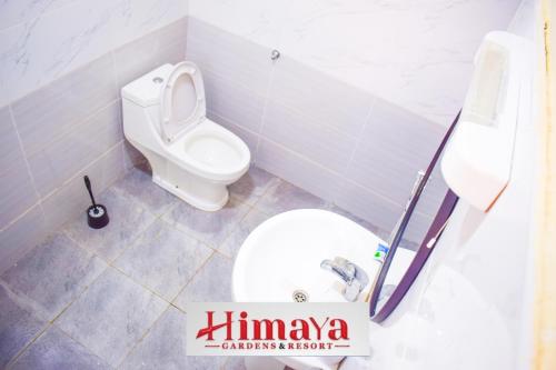 a bathroom with a white toilet and a sink at Himaya Garden in Lanet