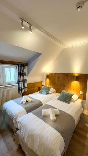 two beds in a hotel room with two bedsvisor at B&B La Ferme de l'Hosté in Wavre