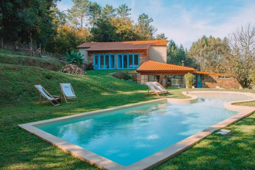 a swimming pool in the yard of a house at Just Like Home - Casa do Botijal in Caminha