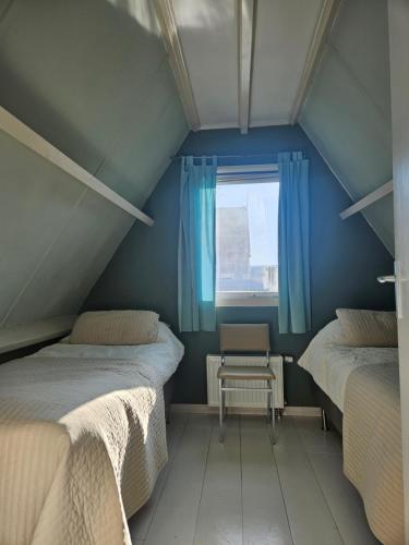 a attic room with two beds and a window at Lovely holiday house in Durgerdam in Amsterdam