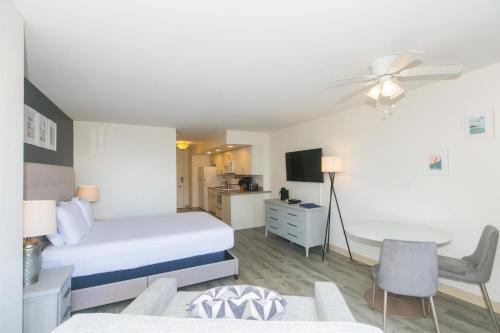 a hotel room with a bed and a desk and a table at Ilikai Marina 1781 in Honolulu