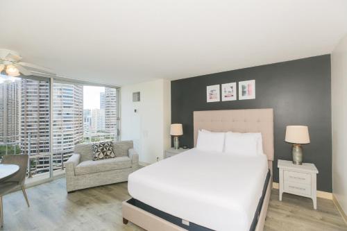 a bedroom with a large white bed and a chair at Ilikai Marina 1781 in Honolulu