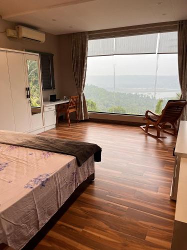 a bedroom with a bed and a large window at Nethra Darshan in Mangalore