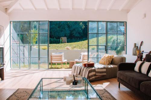 a living room with a couch and a glass table at Just Like Home - Casa do Botijal in Caminha