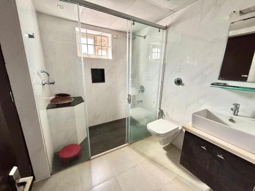a bathroom with a shower and a toilet and a sink at Nethra Darshan in Mangalore
