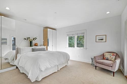 a white bedroom with a large bed and a chair at Perfect Friends Getaway in Sonoma in Sonoma